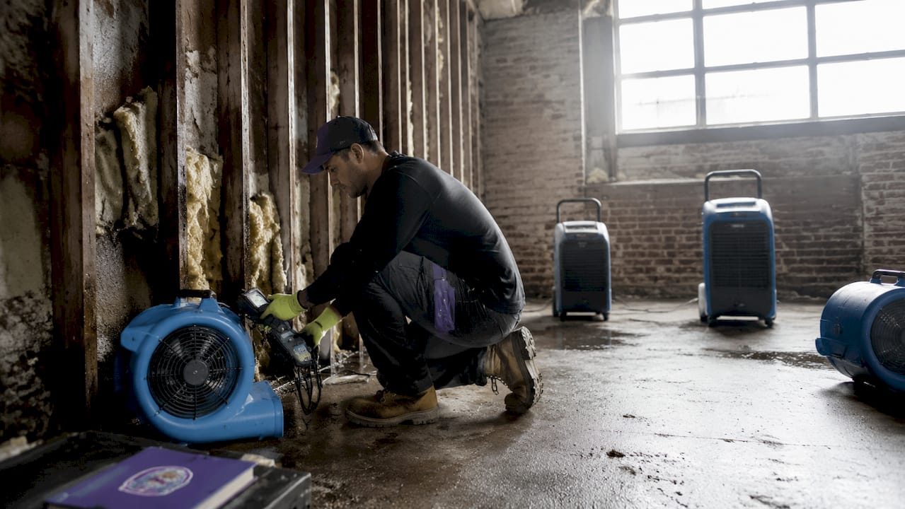 Technician setting up structural drying equipment indoors