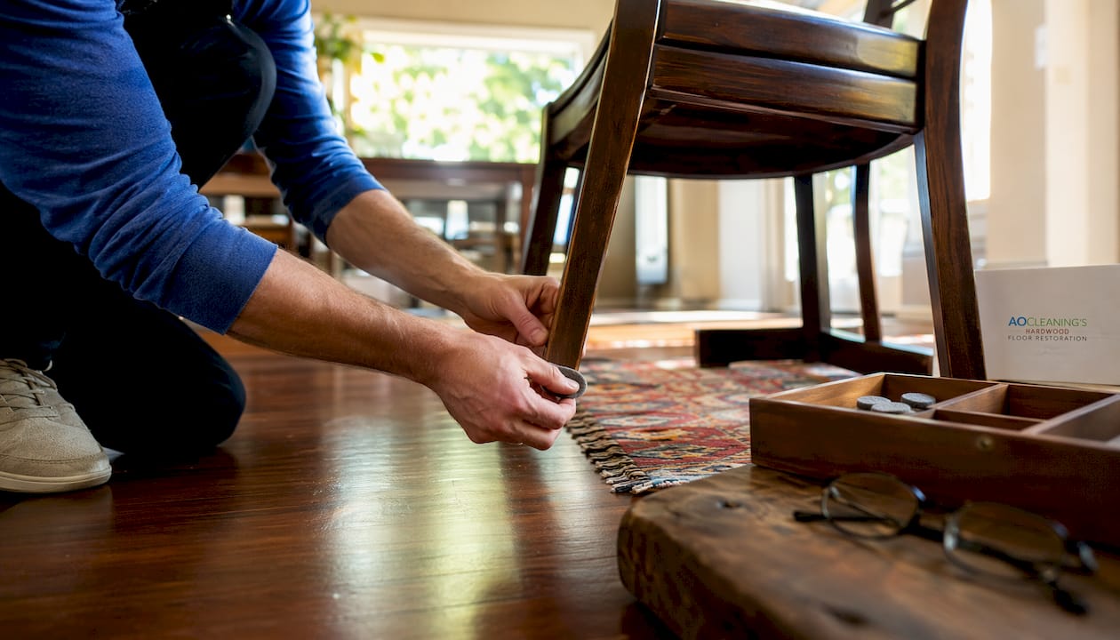 Hands attaching felt pads under chair legs