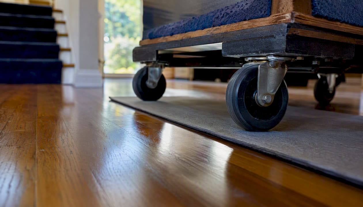 Rubber-wheeled dolly crossing threshold on hardwood floor