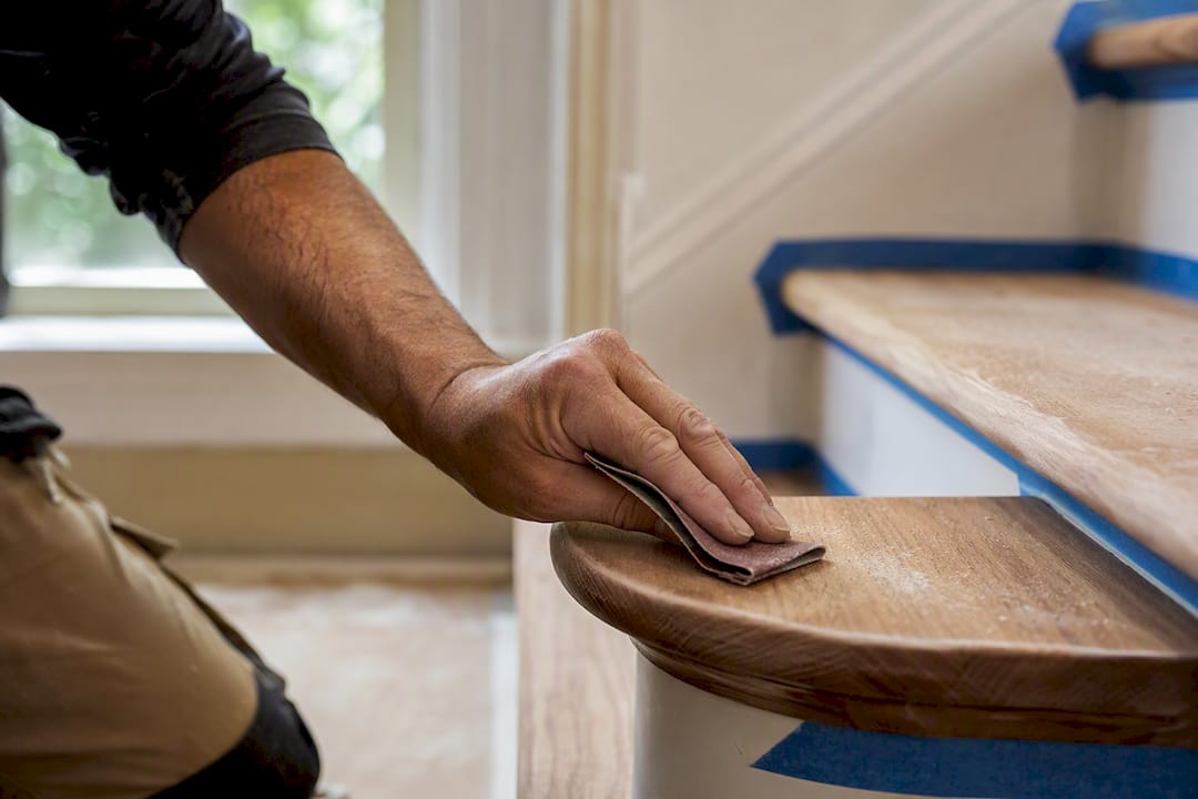 Hand sanding hardwood stair nosing