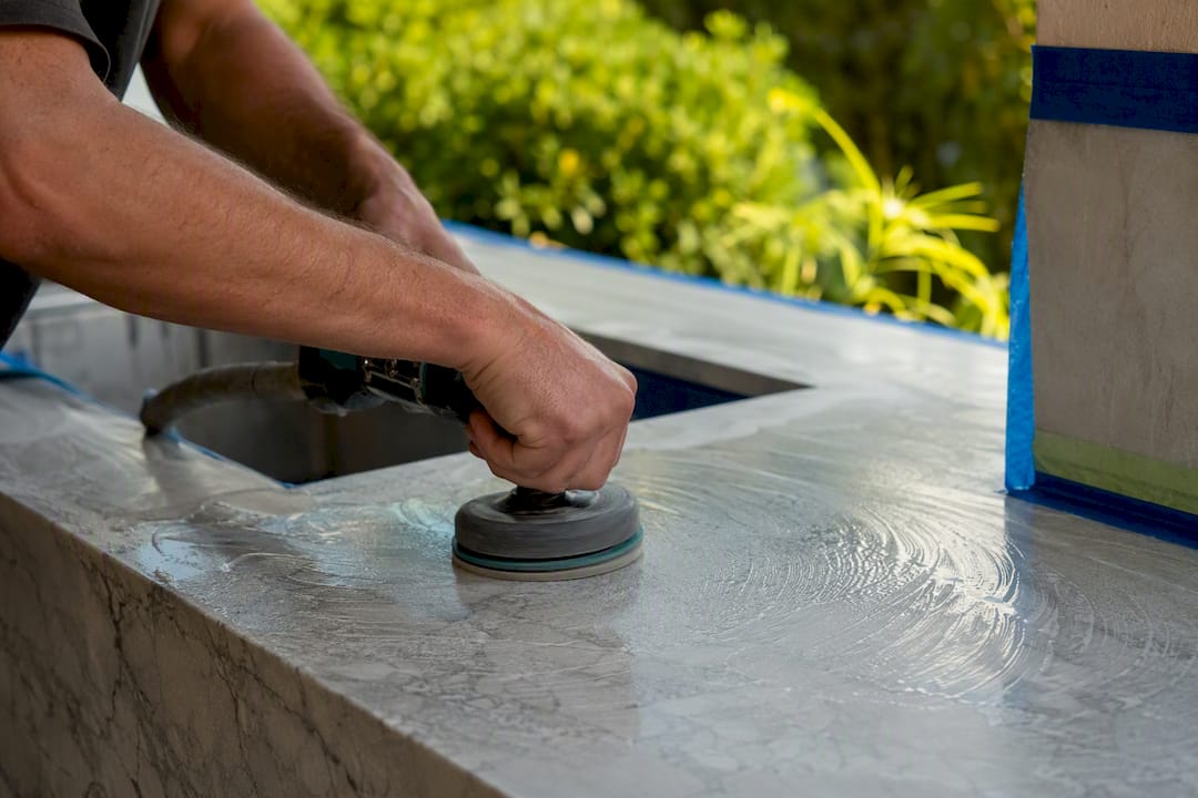 Hands using polisher on marble surface