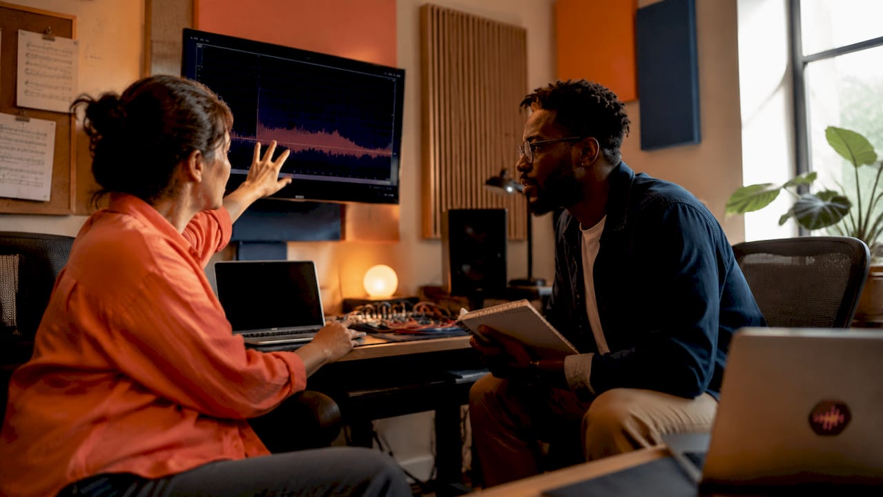 Two audio professionals collaborating on feedback in recording studio