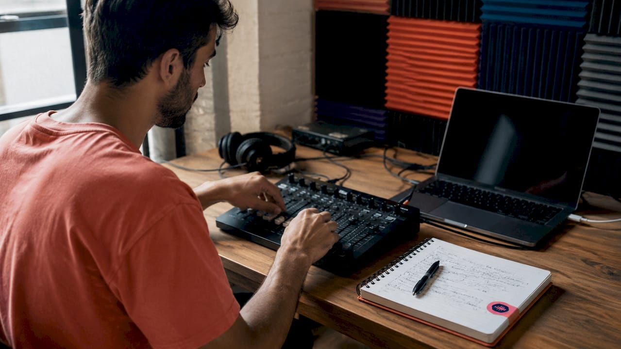 Hands adjusting mixing board sliders in studio