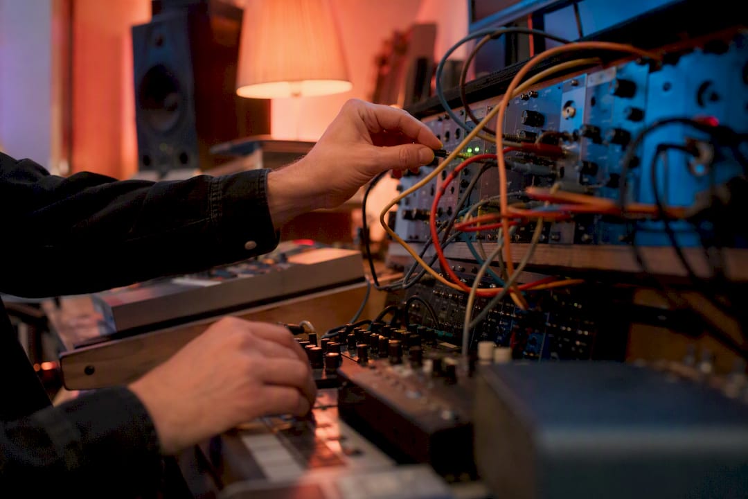 Hands reconnecting audio cables on desk
