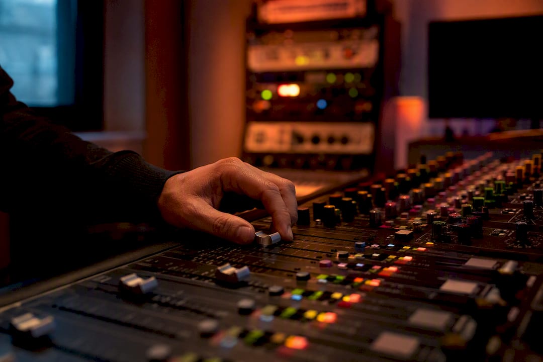 Hand adjusting mastering studio control knobs