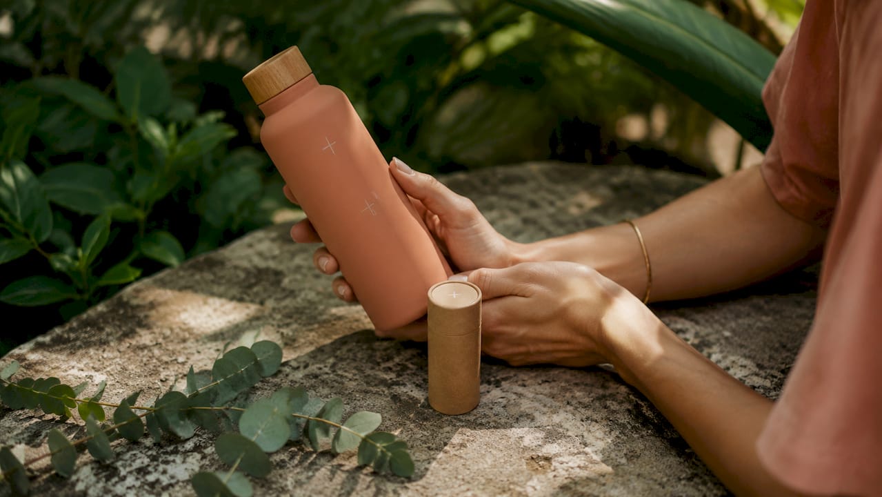 Hands holding sustainable green beauty products on wood