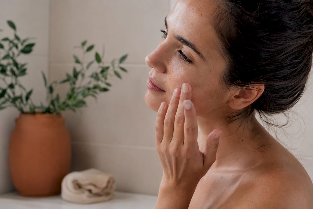 Fingertips patting essence into facial skin gently