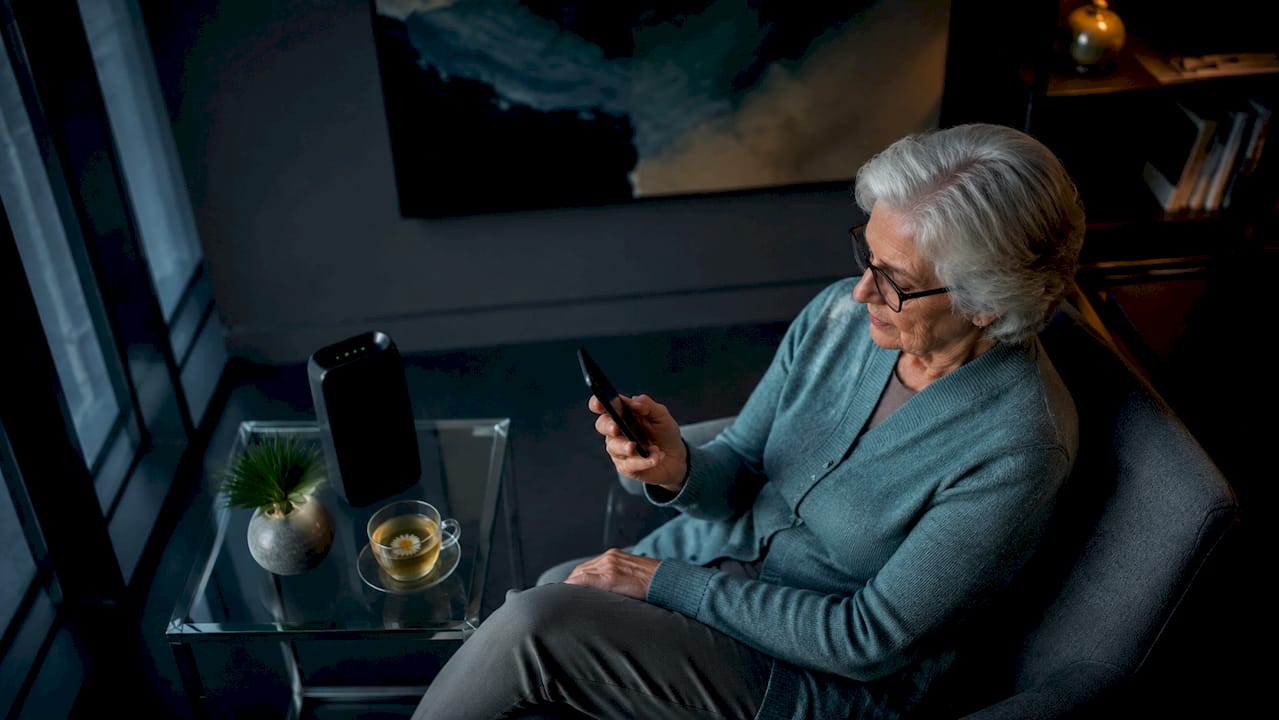 Senior woman checking phone signal indoors