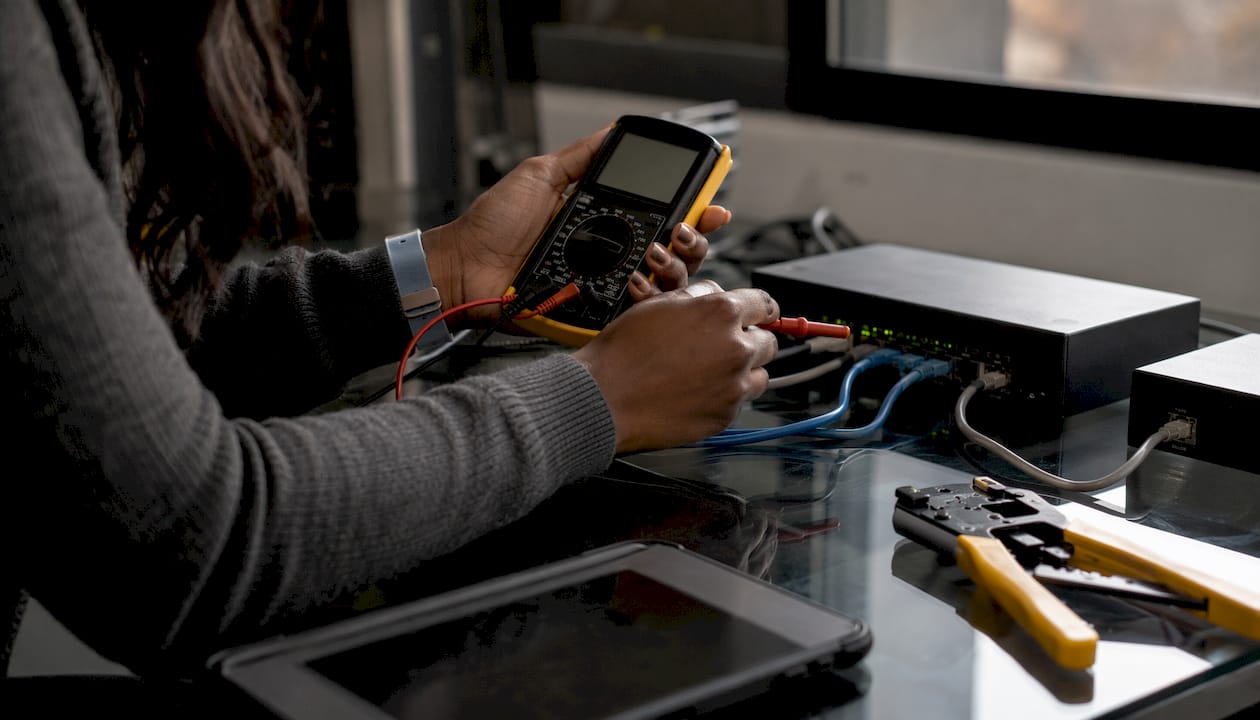 Hands measuring PoE Ethernet cable signals