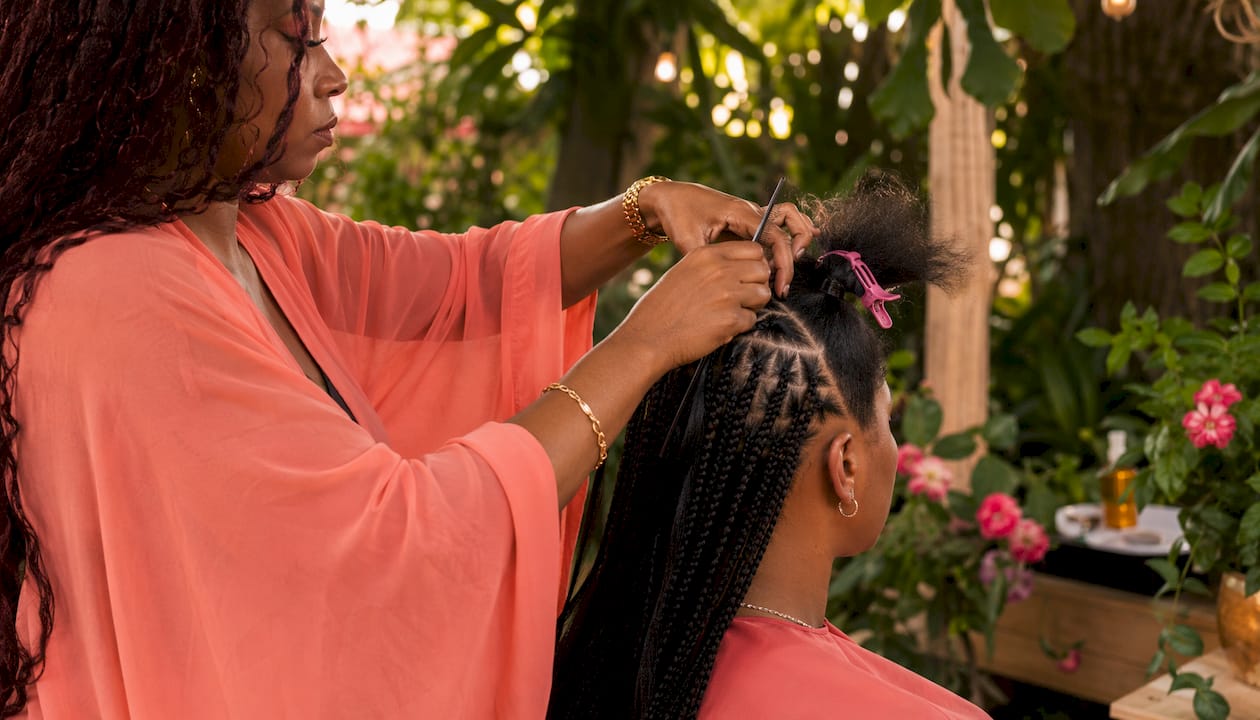 Hairstylist installing protective braids carefully