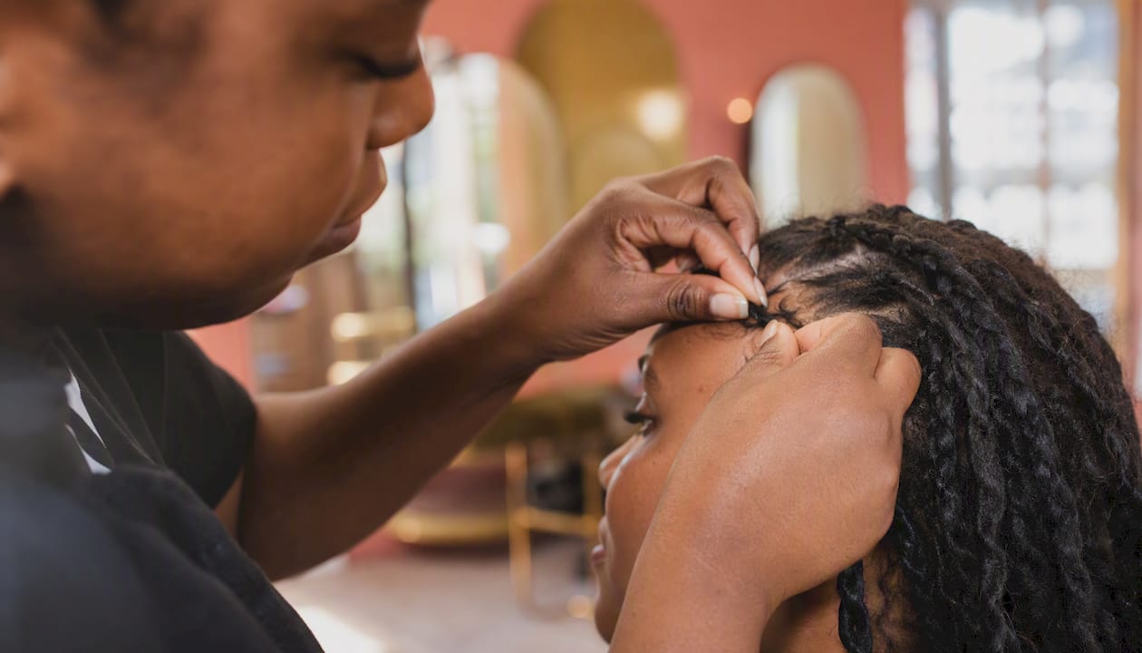 Stylist braiding hairline edges carefully