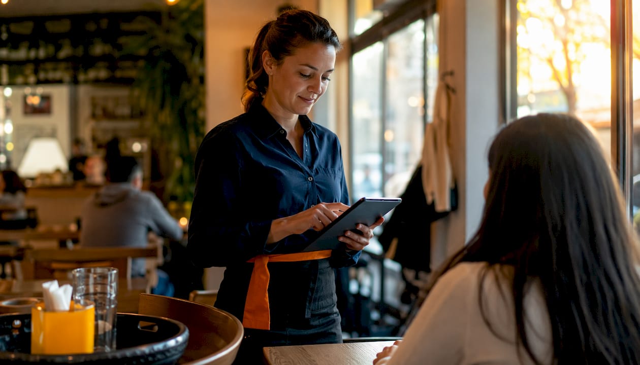 Restaurant server processing payment via tablet