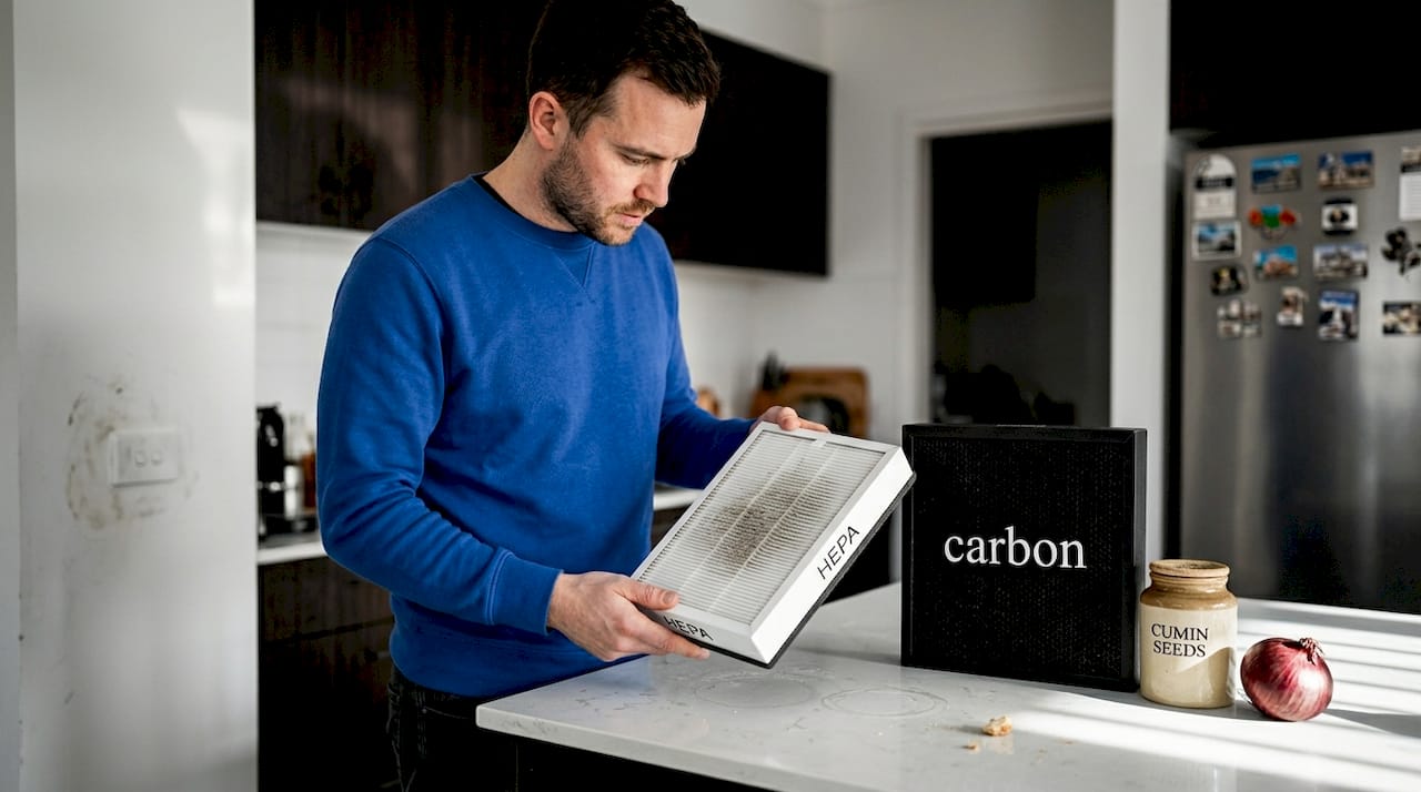 Man examines HEPA and carbon filters side by side