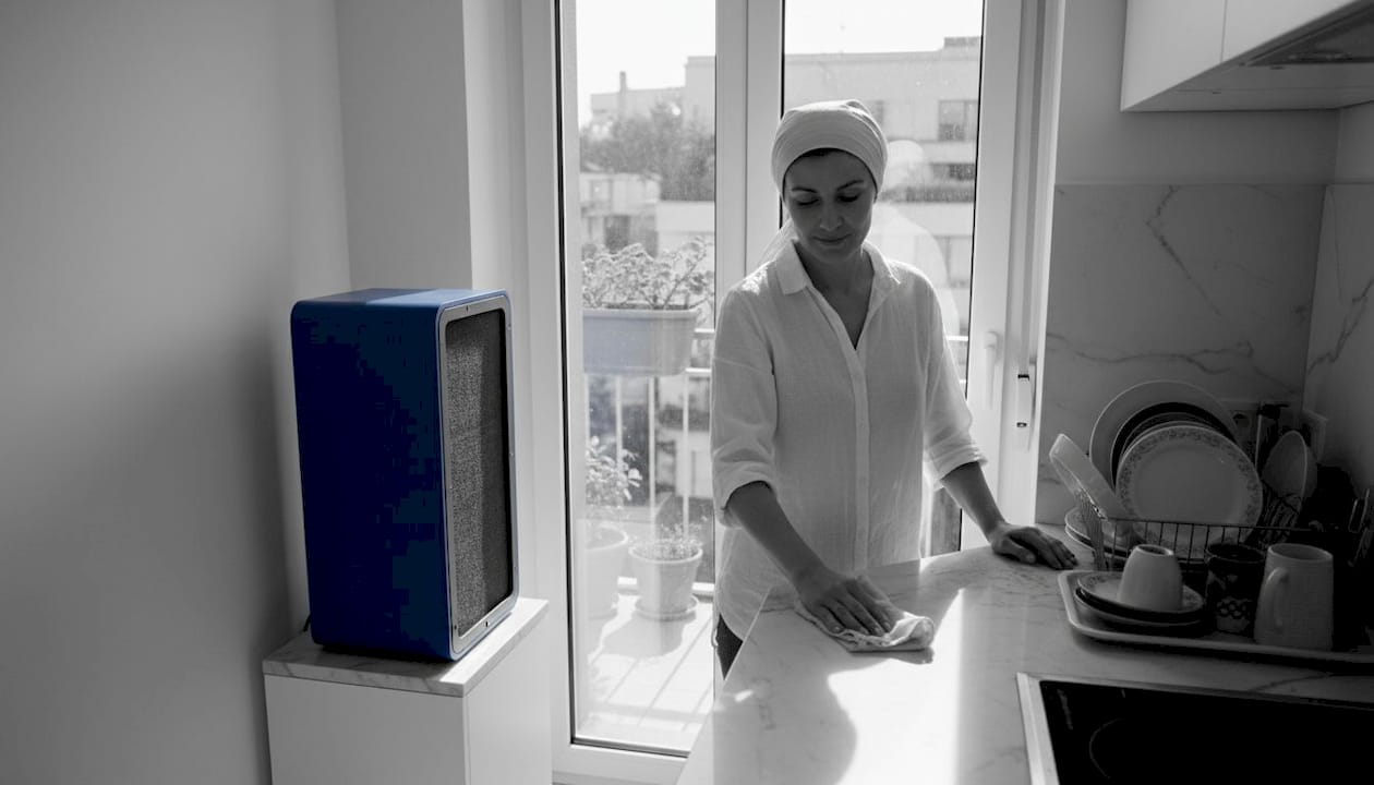 Woman cleaning by kitchen air purifier