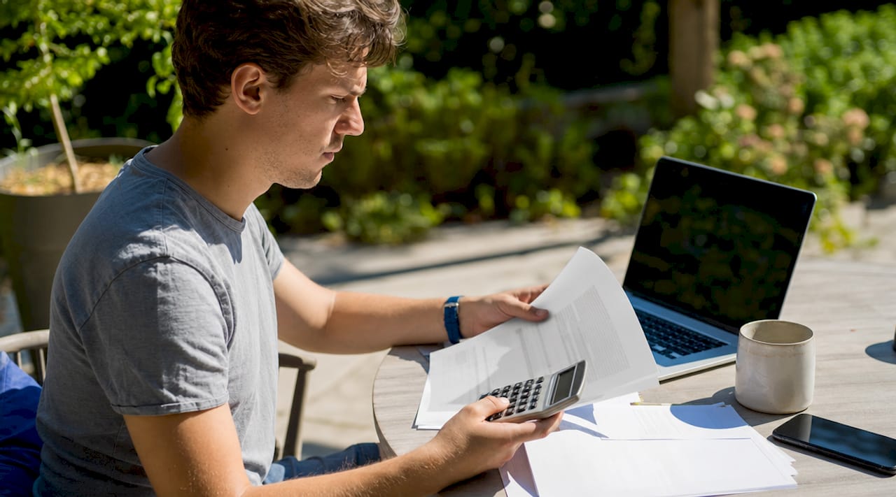 Man calculating home's air exchange rate at kitchen table