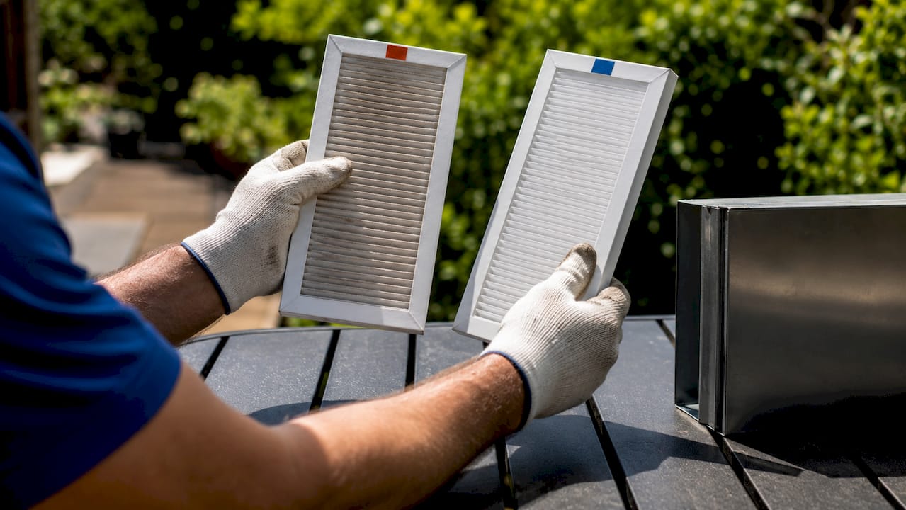Hands comparing MERV 8 and MERV 13 air filters