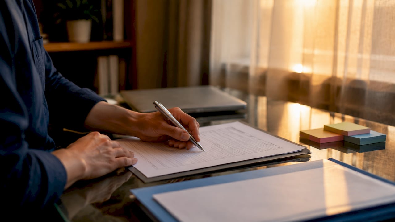 Close-up of hand completing business license form