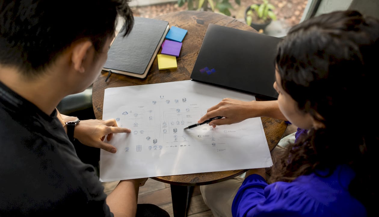Diverse hands pointing at network diagram