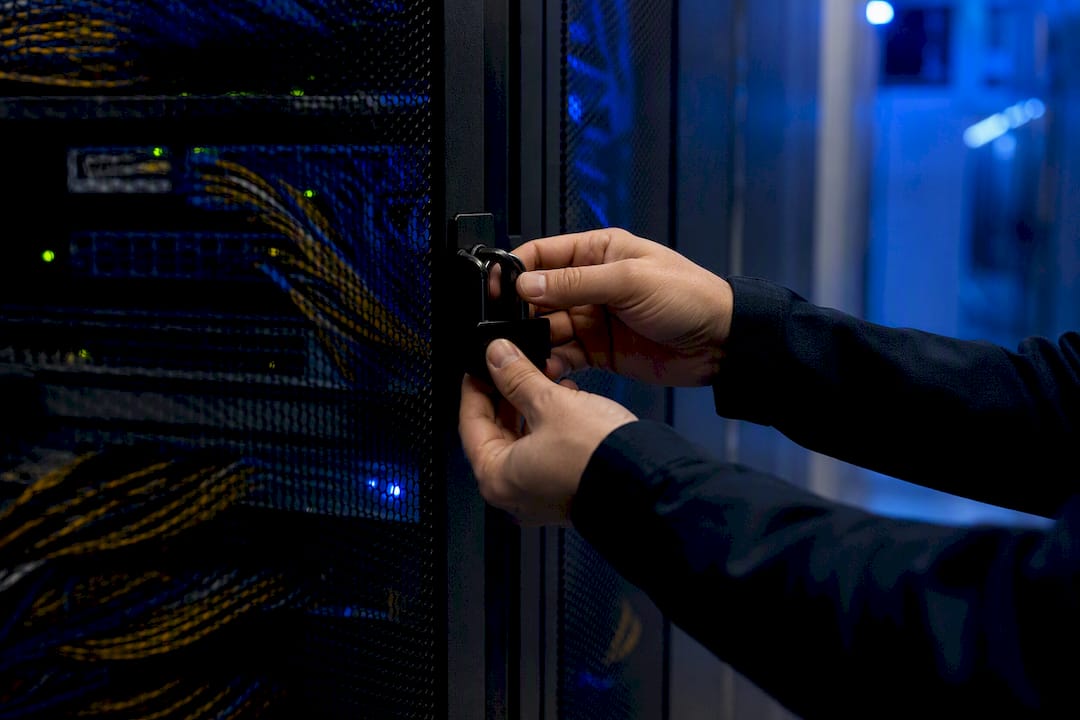 Hands securing locked network equipment rack