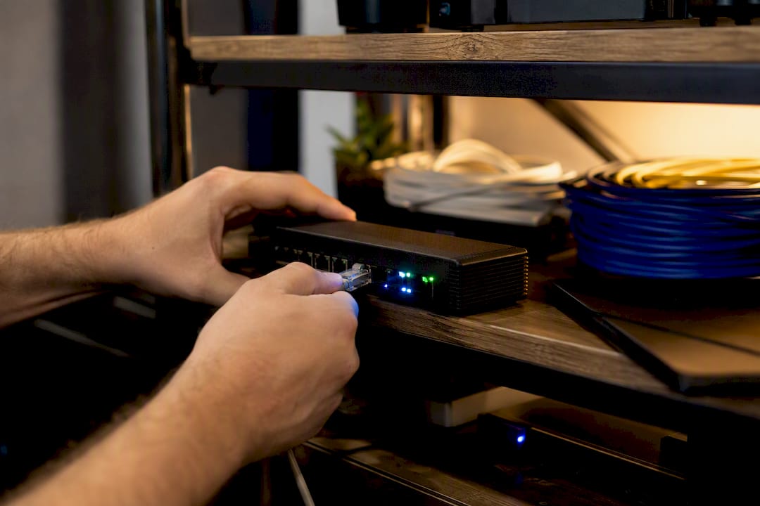 Hands connecting cable to edge network device