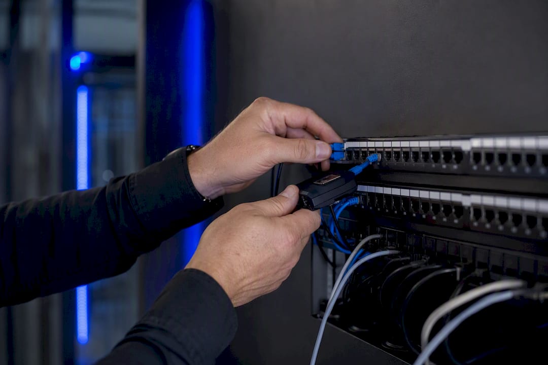 Hands installing packet capture probe on network cable