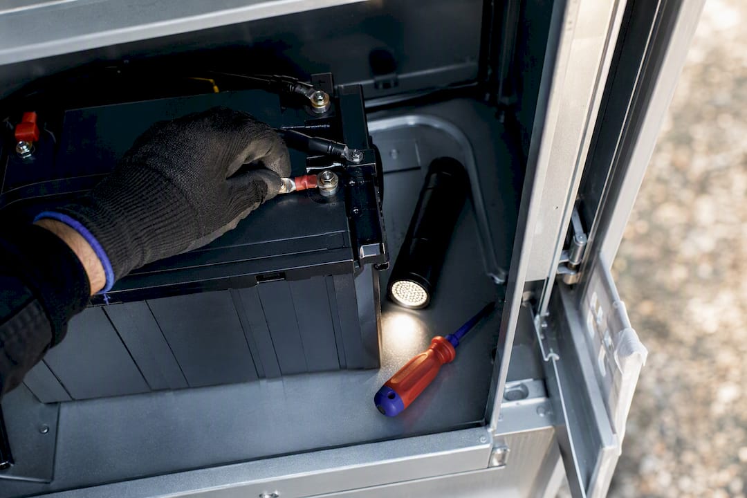 Technician inspecting remote-site backup battery