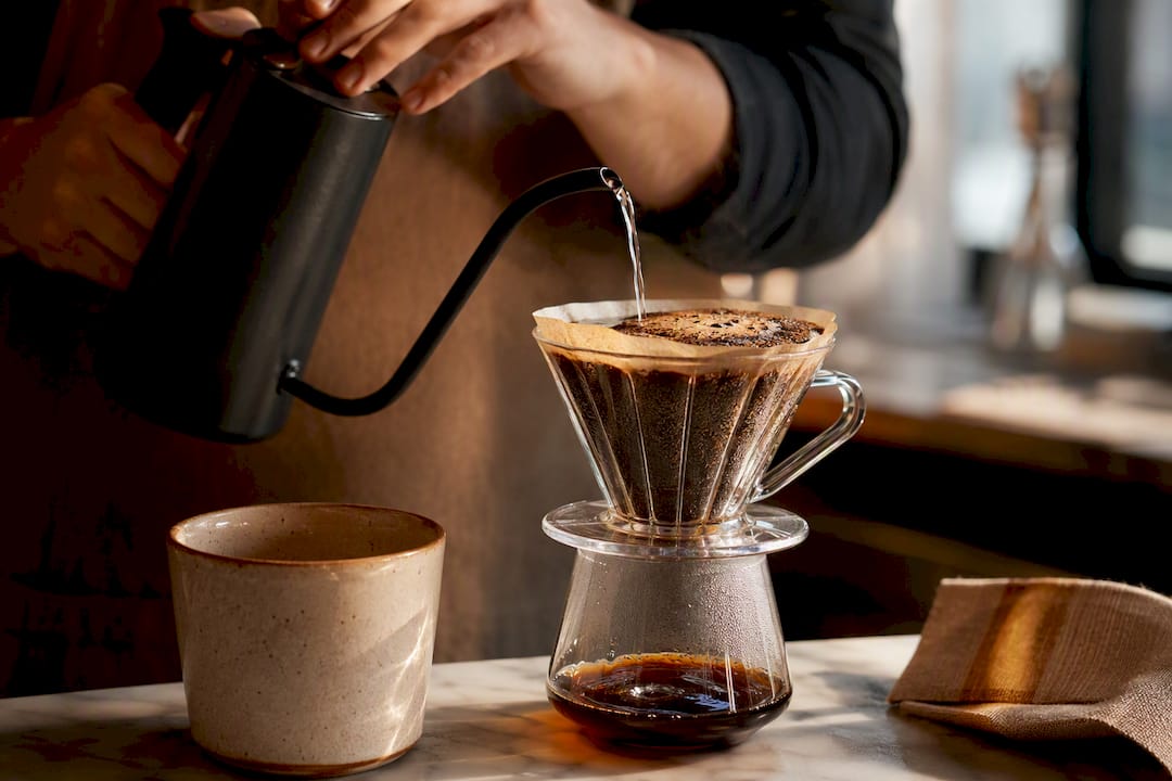 Hands brewing decaffeinated coffee grounds