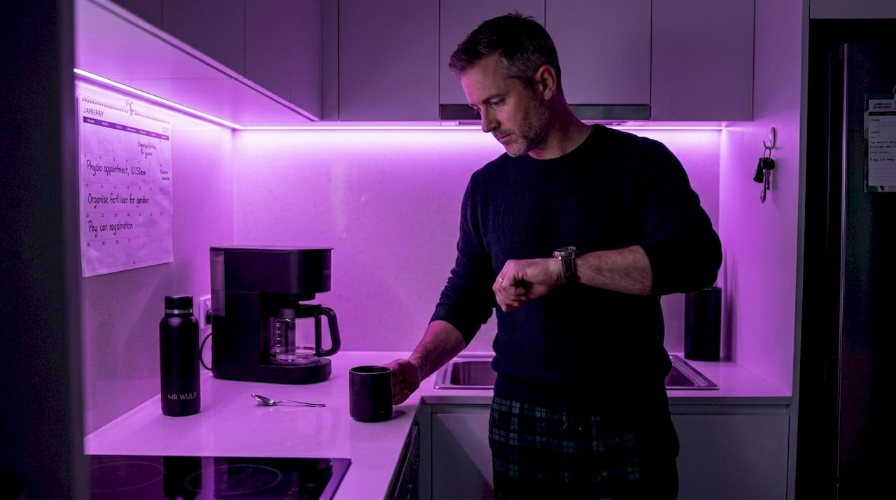 Man considers evening coffee in quiet kitchen
