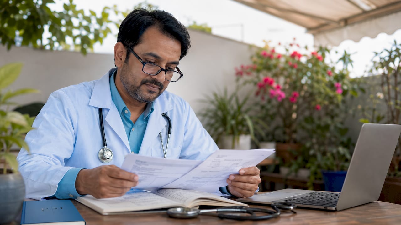 Doctor studying patient review documents in office