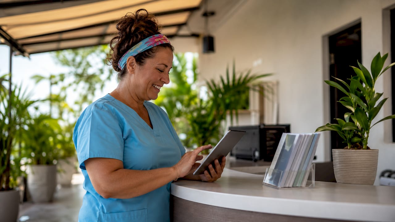 Clinic receptionist using healthcare chatbot tablet