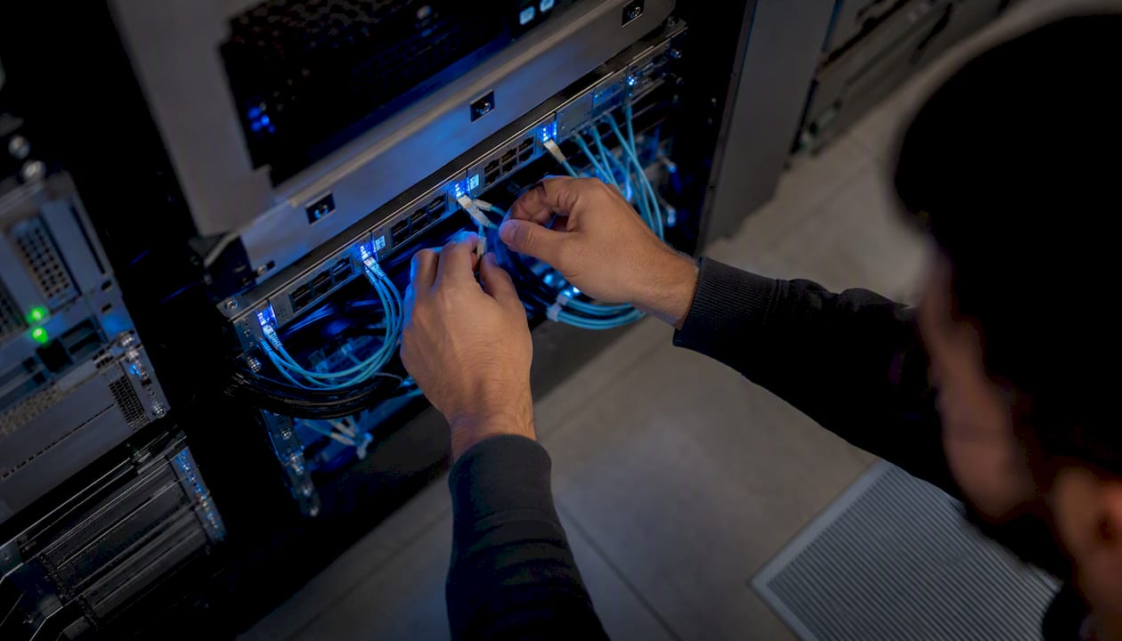 Hands connecting cables in healthcare server room