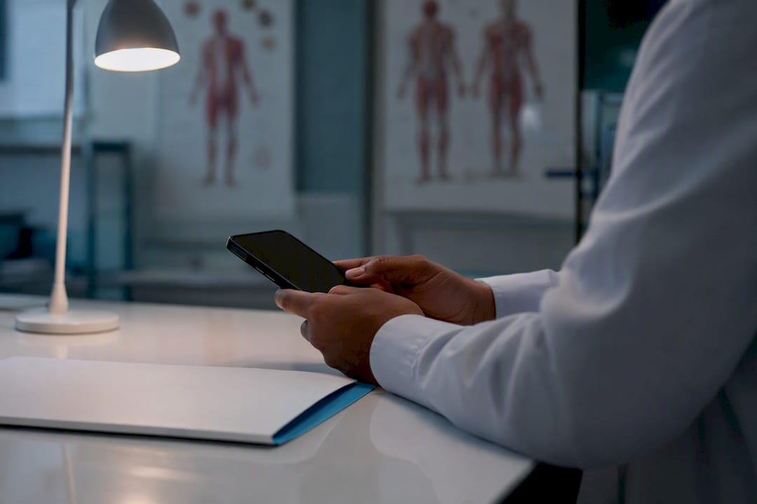 Hands holding medical office phone for follow-up