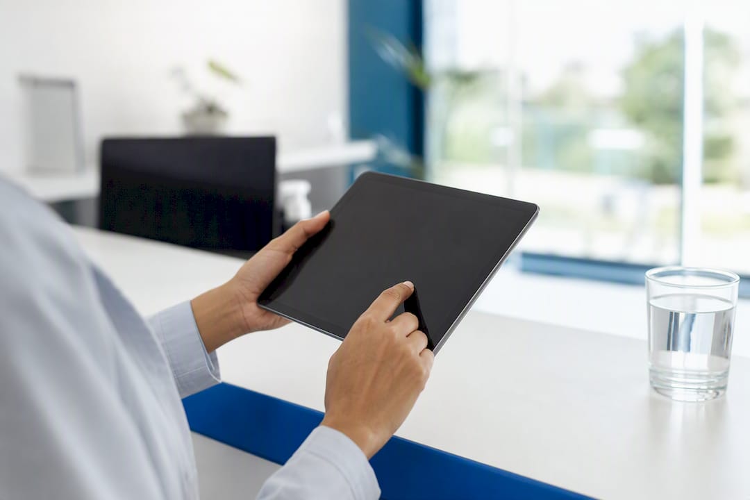 Hands holding tablet in clinic environment