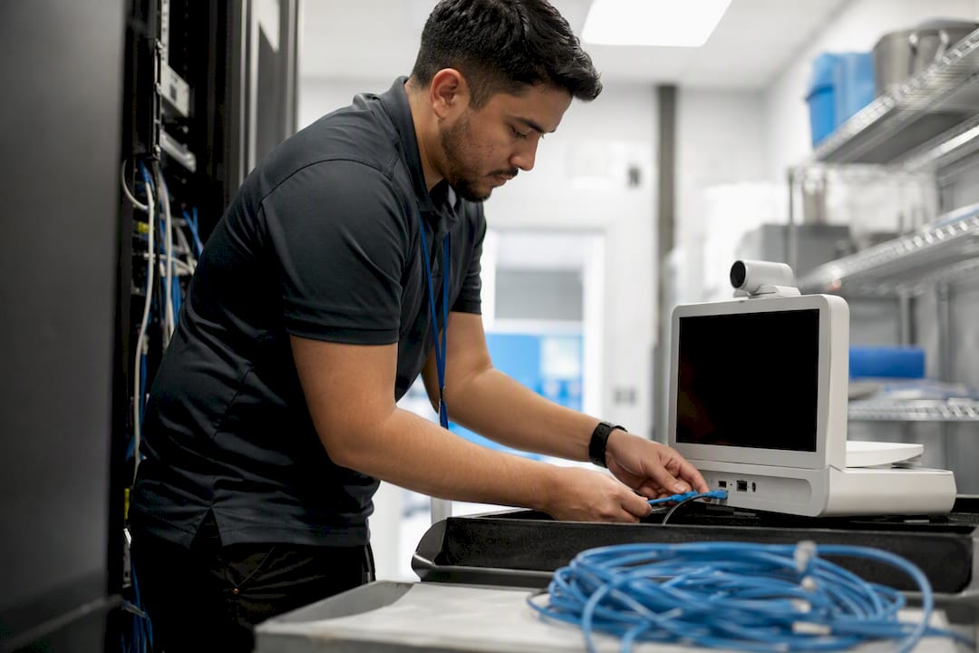Hands connecting cable to telehealth device