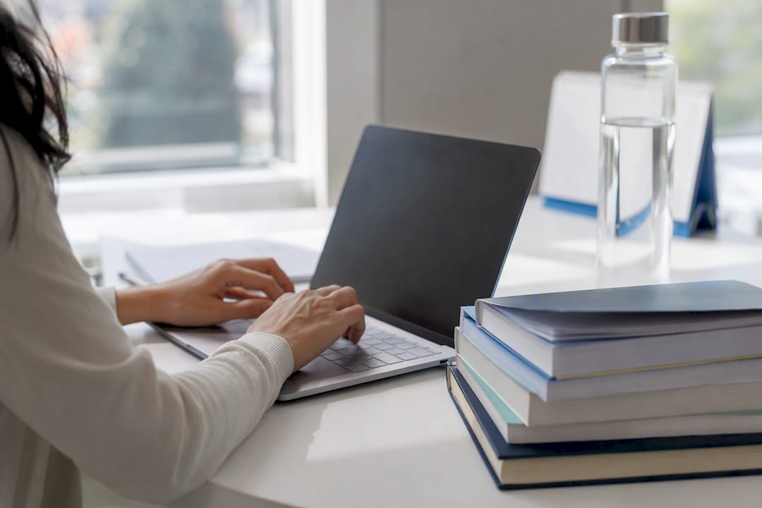 Hands typing on laptop in healthcare office