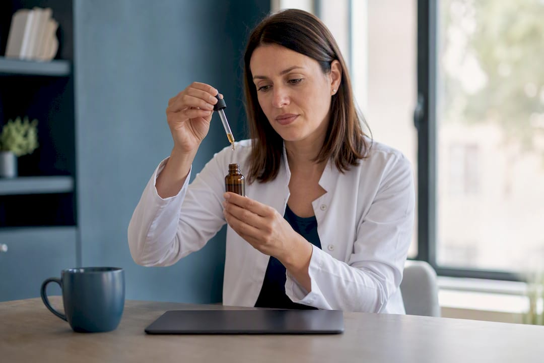 Hände zeigen die Mikrodosierung von Cannabisöl