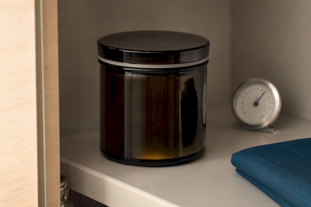 Lichtundurchlässiges Glasgefäß mit Hygrometer im Schrank