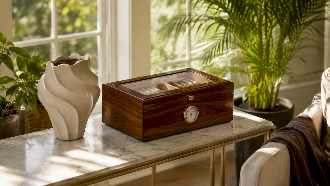 Close-up walnut humidor on leather table with lamp