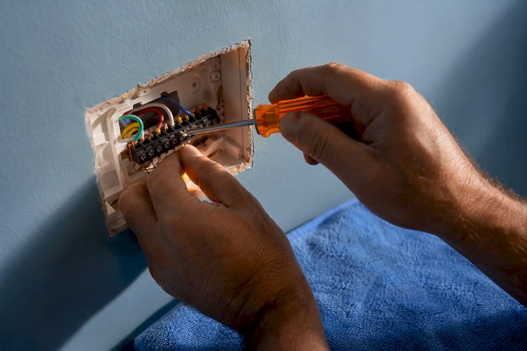 Technician inspecting thermostat wiring