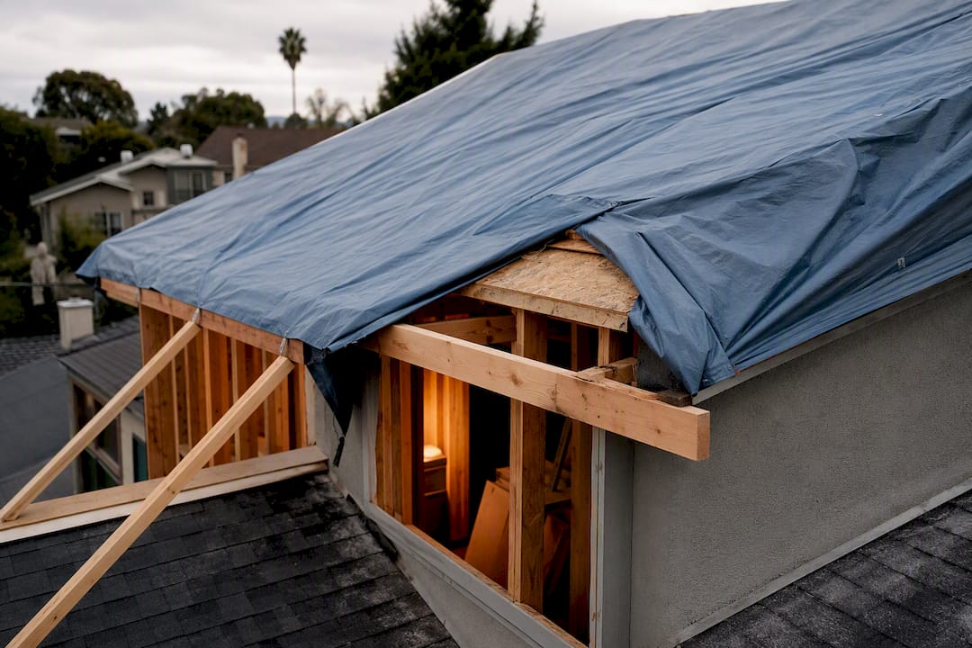 Tarp protecting roof during second story construction
