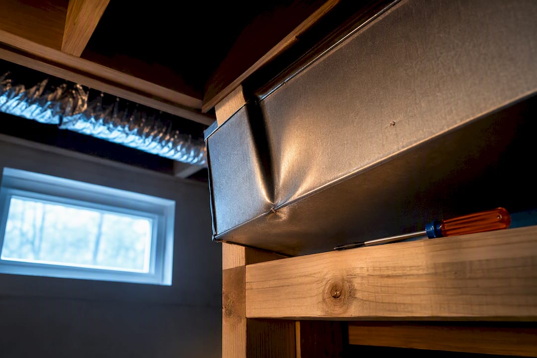 Sheet-metal duct near floor joist