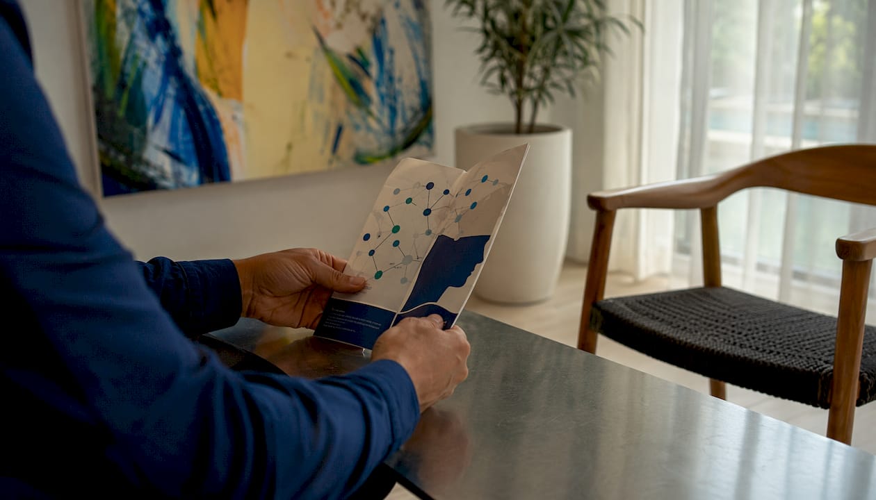 Hands browsing nerve stimulation brochures on desk