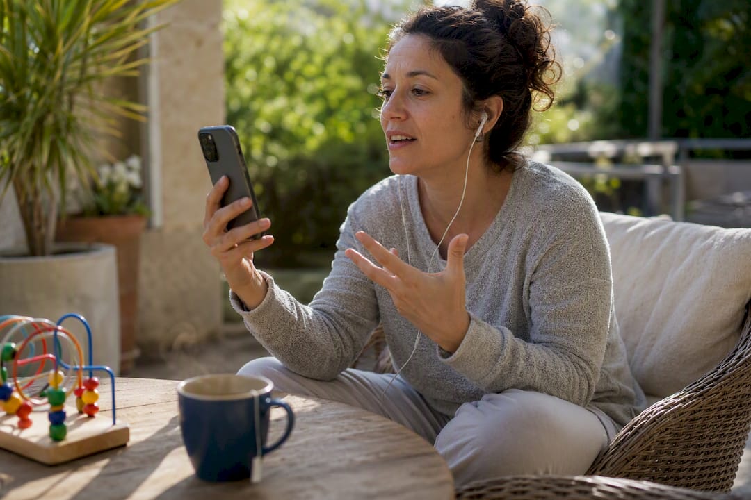 Working parent having telehealth call on smartphone