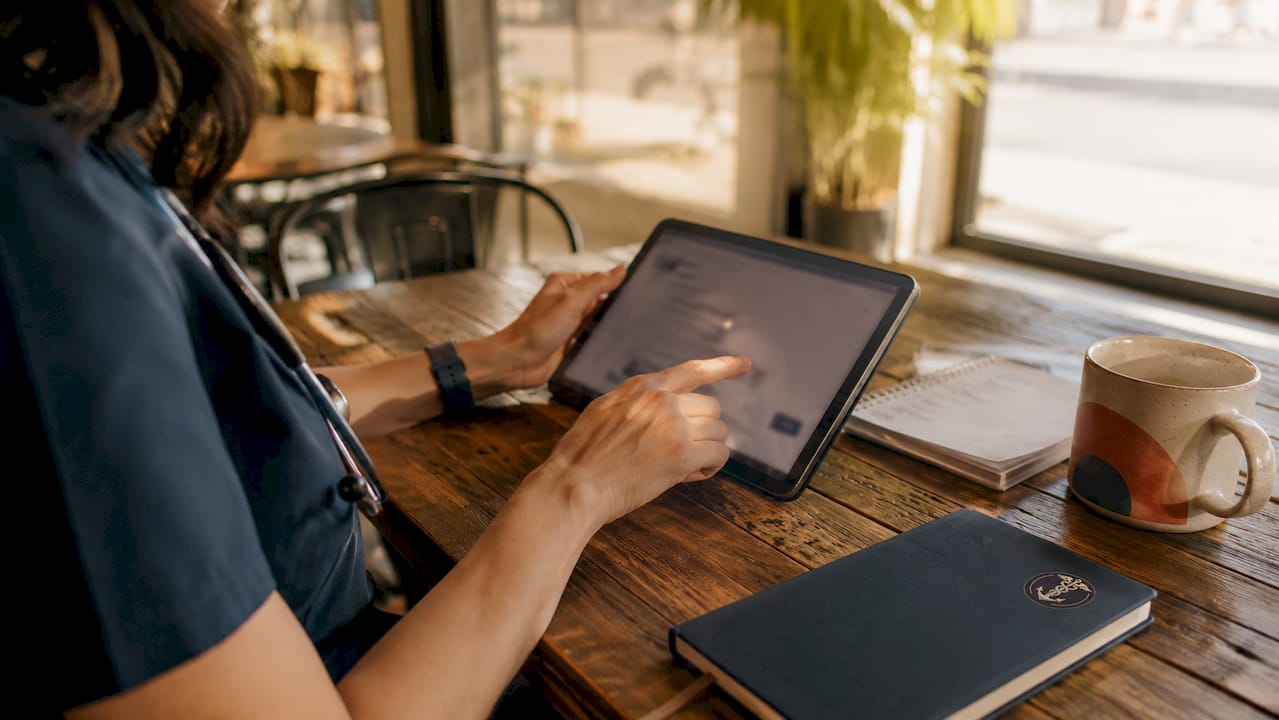 Healthcare worker operating AI triage tablet in clinic