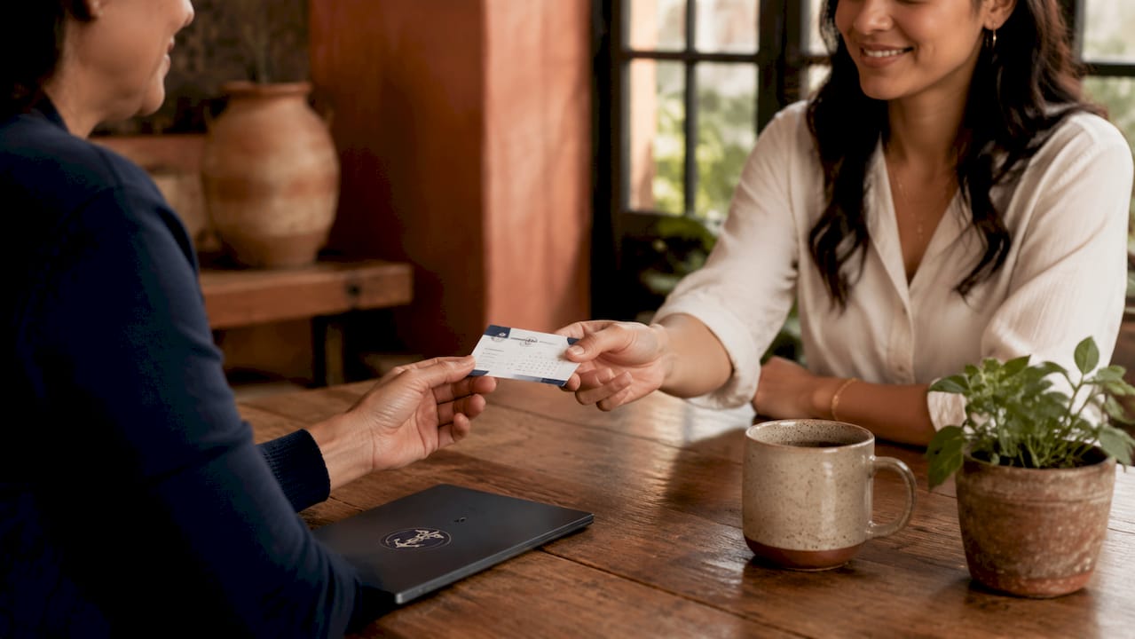 Close-up of hands exchanging appointment reminder card