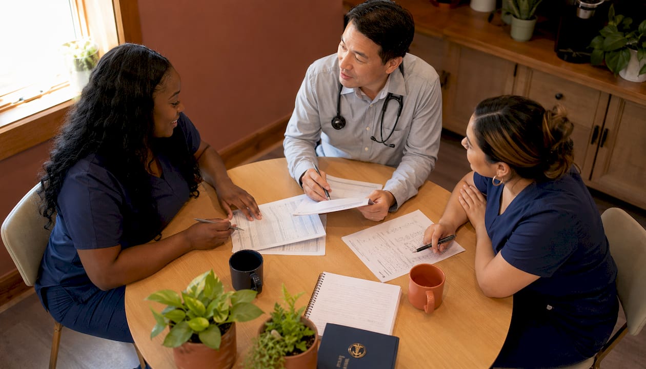 Family medicine team collaborating around meeting table