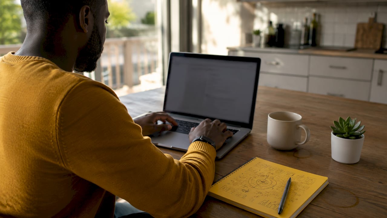 Hands typing email marketing strategy in home office