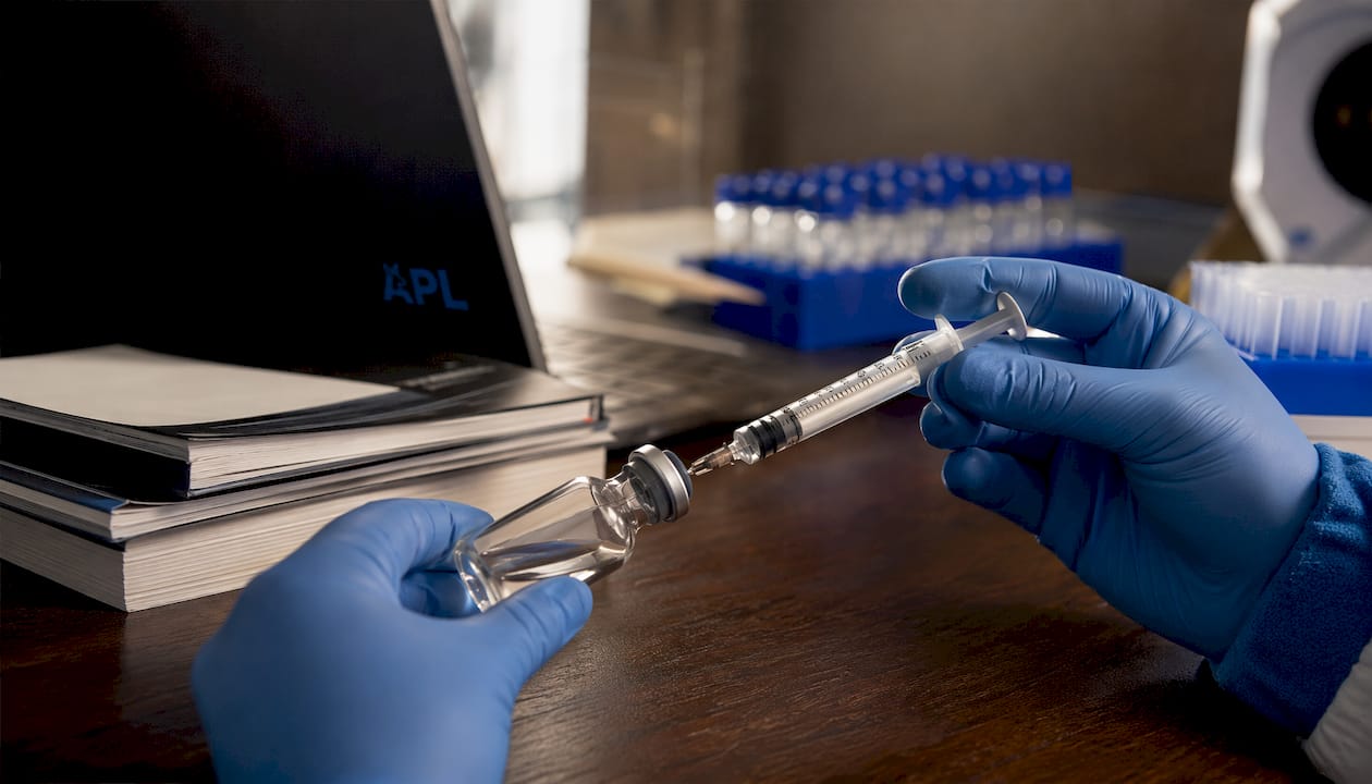 Close-up of vial and syringe in lab setting