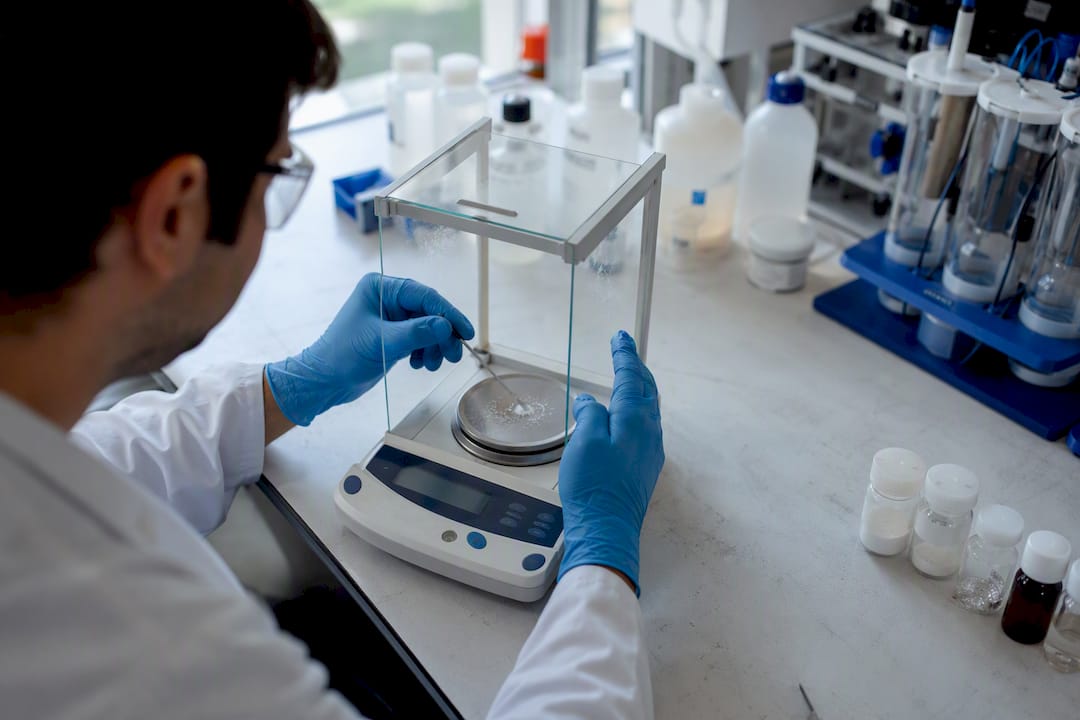 Scientist adjusting scale with peptide samples