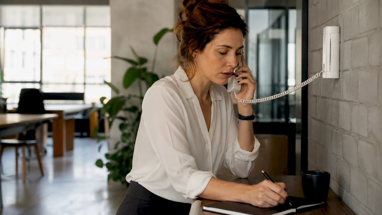 Une collaboratrice échange via l’interphone dans les locaux de l’entreprise.